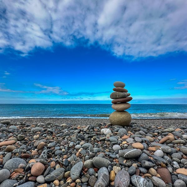 A balanced stack of stones on a calm surface, representing balance and philosophy.